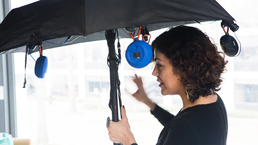 woman standing under an umbrella at the AI and arts event