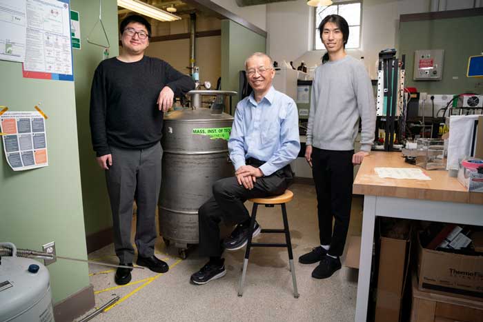 Guangxin Lv, Gang Chen, James Zhang stand in the lab and pose for a photo. Lv’s arm rests on a large gas tank.